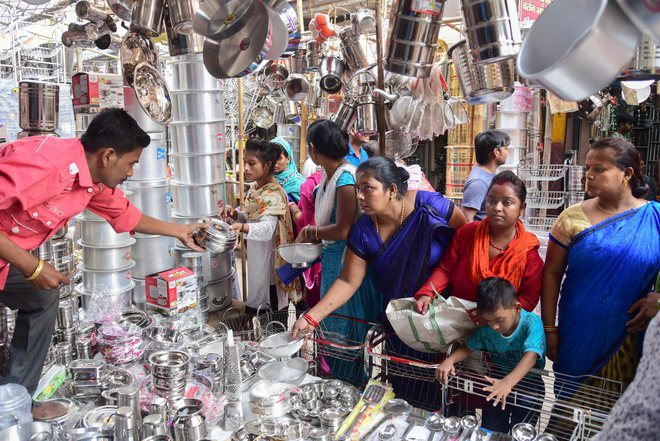 People buy utensils at a shop on the occasion of Dhanteras festival, in Allahabad
