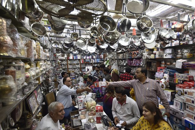 People buy utensils at a shop on the occasion of Dhanteras festival, in New Delhi