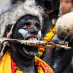 A Hindu devotee of Lord Shiva holds a human bone with his teeth as he takes part in a religious procession to mark the Hindu festival of Maha Shivratri in Allahabad