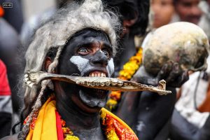 A Hindu devotee of Lord Shiva holds a human bone with his teeth as he takes part in a religious procession to mark the Hindu festival of Maha Shivratri in Allahabad