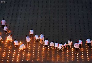 People light candles as 330,000 of them are arranged in the shape of the earth to set a Guinness World Record during Earth Day, Thailand