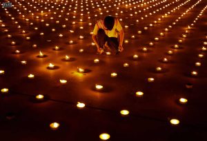 A person lights a candle as 330,000 of them are arranged in the shape of the earth to set a Guinness World Record during Earth Day, Thailand