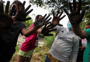 Activists show their muddy hands after planting trees to mark Earth Day, in Villeta, Colombia