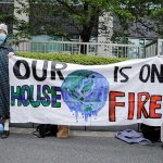 Young climate activists hold a banner as they attend a rally to mark the World Earth Day in Tokyo, Japan