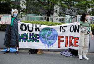 Young climate activists hold a banner as they attend a rally to mark the World Earth Day in Tokyo, Japan