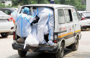 Health workers wearing PPE kits carry the body of a COVID-19 victim from a mortuary for cremation, in Patiala on May 4, 2021