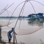 Villagers catch fish in flood waters in Assam’s Morigaon district on July 5, 2021