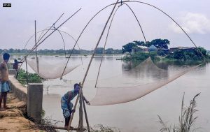 Villagers catch fish in flood waters in Assam’s Morigaon district on July 5, 2021