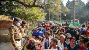 Security personnel keep vigil as passengers move towards the Prayagraj railway station