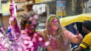 Foreign tourists participate in Holi celebrations along with locals in Paharganj, in New Delhi