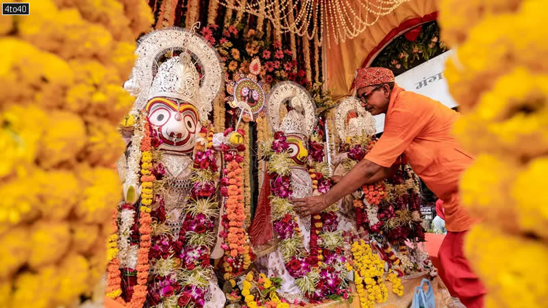 A priest attends to the idols of Lord Jagannath, Lord Balabhadra and Goddess Subhadra